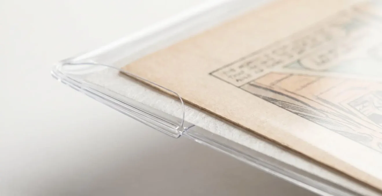 Gros plan macro sur une pochette de conservation professionnelle transparente contenant une planche de bande dessinée, révélant les détails de texture du papier et les normes de préservation